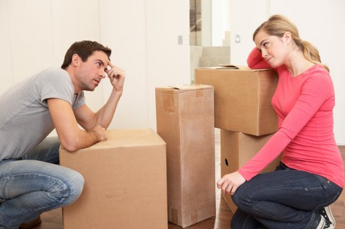 Local movers carrying furniture through a residential building in Maida Vale